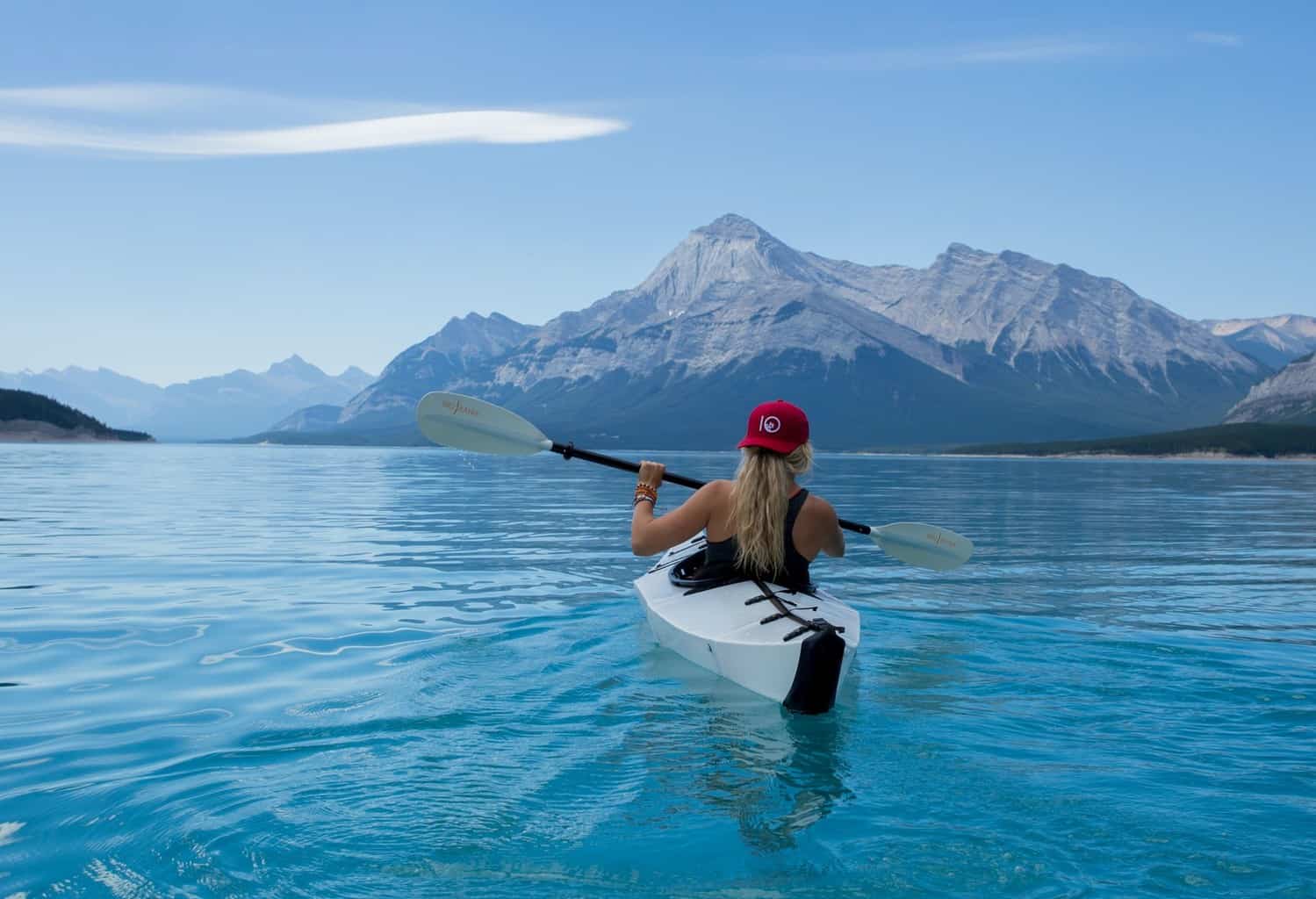 woman kayaking on blue lake